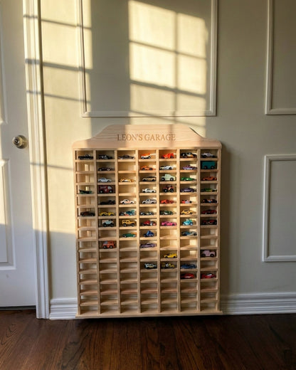 Wooden toy car garage with multiple small cars inside, labeled 'Leon's Garage', against a neutral wall.
