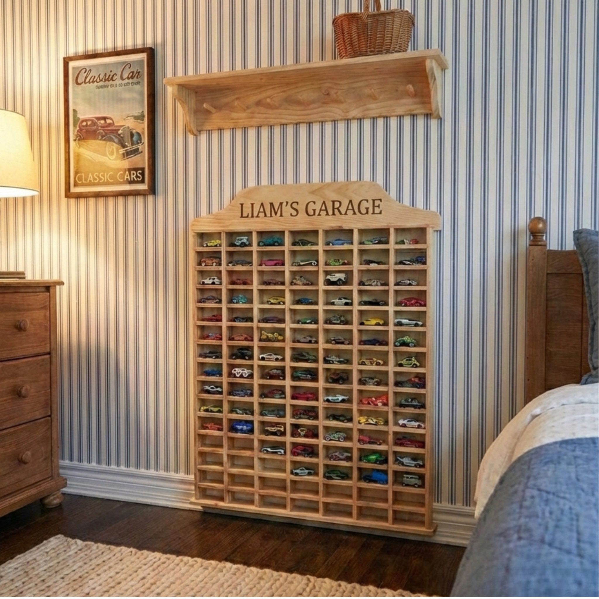 Wooden toy car display case with 'Liam's Garage' on a wall with striped wallpaper.