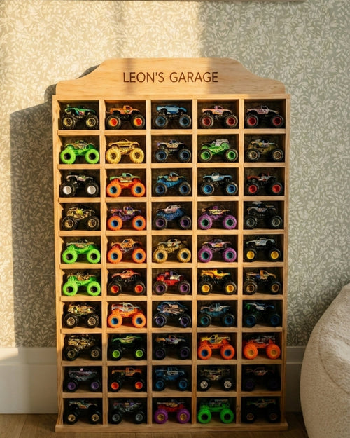 Wooden toy car organizer with 'Leon's Garage' at the top, filled with small toy cars.