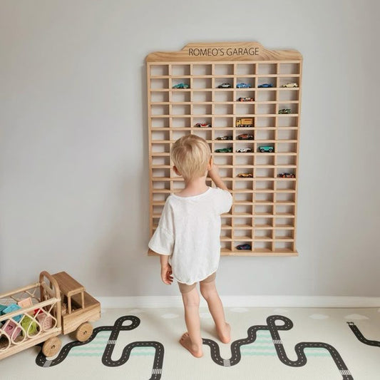 Child organizing cars in a personalized wooden Montessori garage

